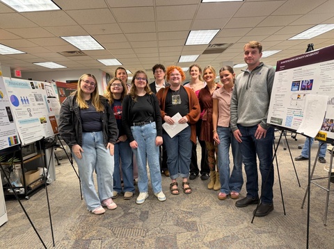 German students pose with research posters at German Meifeier event