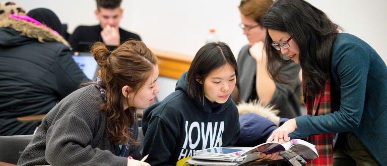 Students and instructor pointing at a book in a translation class