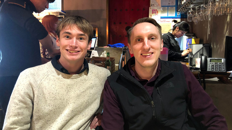Two men smiling next to one another