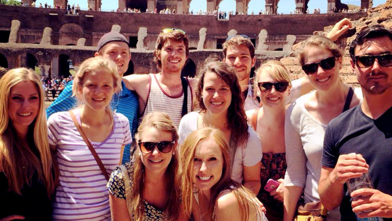 University of Iowa students posing for a group picture in the Coliseum in Rome