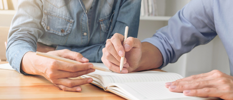 Two people conversing over a sheet of paper