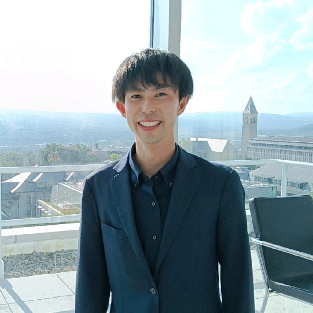 man with brown hair in front of a window
