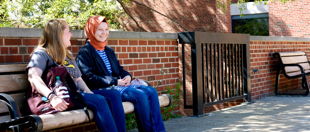 International studies students talking on a bench
