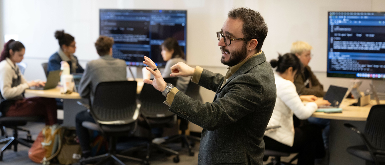 professor teaching to class with arms raised