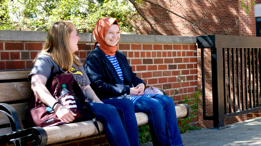International studies students talking on a bench