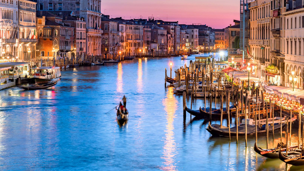 Gondola moving through the canals of Venice at sunset